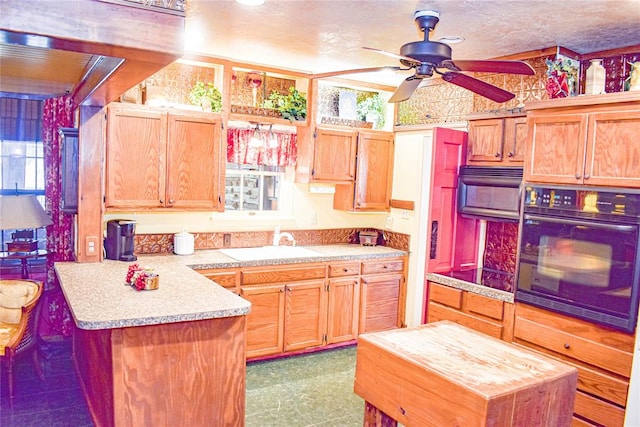 kitchen featuring a center island, oven, ceiling fan, and sink