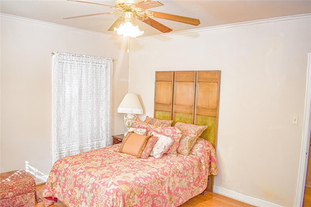 bedroom featuring light hardwood / wood-style flooring, ceiling fan, and crown molding