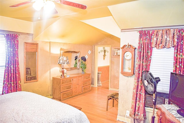 bedroom with ceiling fan, lofted ceiling, and light hardwood / wood-style flooring