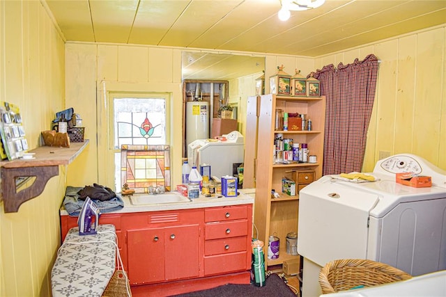 laundry room featuring wood walls, sink, washer / clothes dryer, and water heater