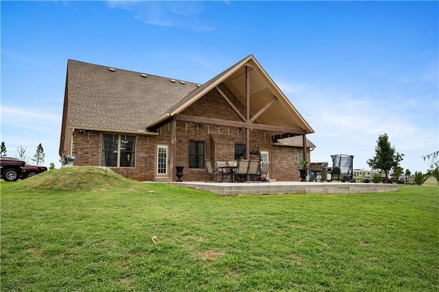 rear view of property featuring a yard and a patio