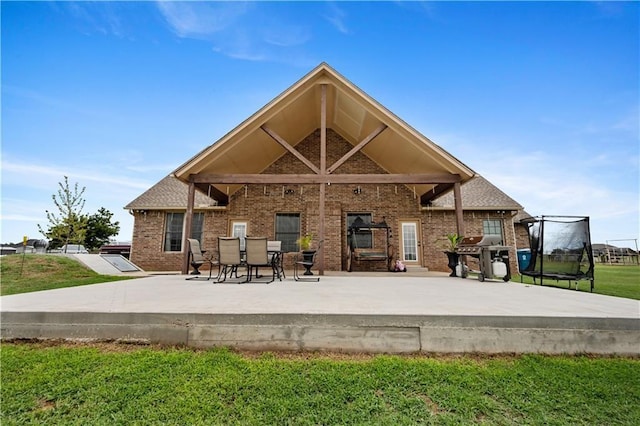 back of property featuring a patio area and a yard