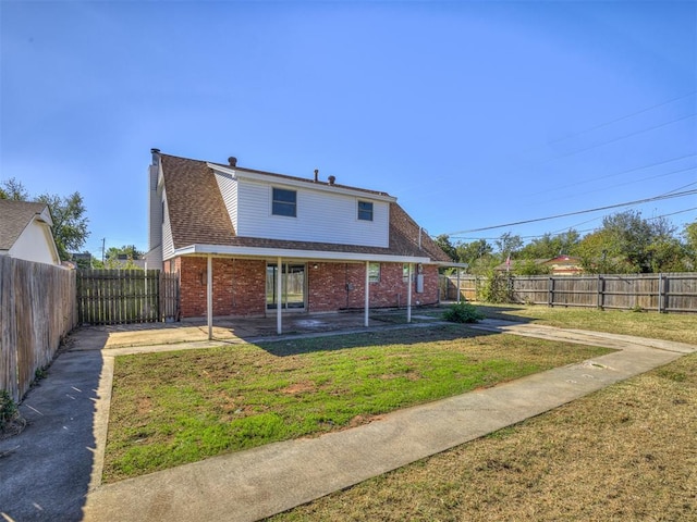 rear view of house with a patio area and a yard