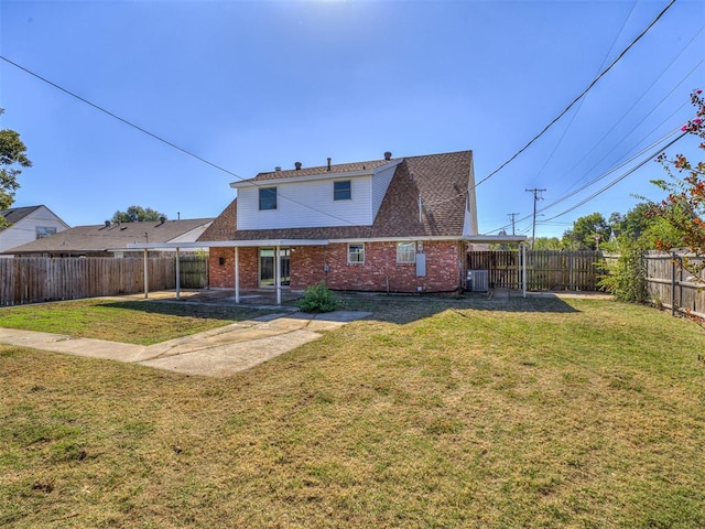 rear view of house featuring central air condition unit, a patio area, and a yard