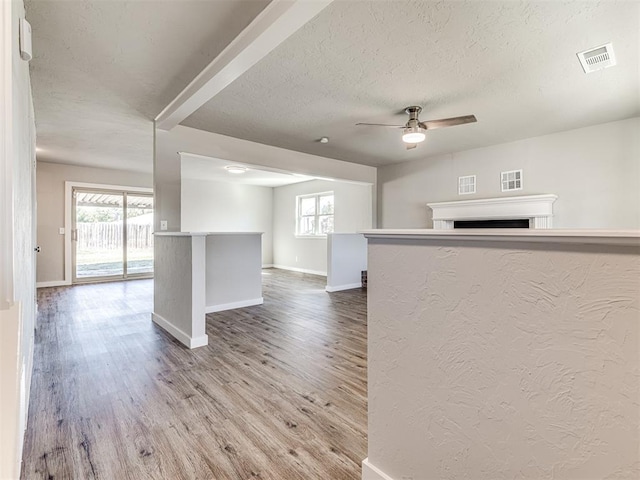 interior space with hardwood / wood-style flooring, ceiling fan, kitchen peninsula, and a textured ceiling