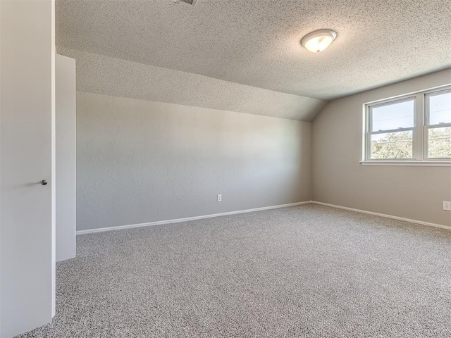 additional living space featuring carpet flooring, a textured ceiling, and vaulted ceiling