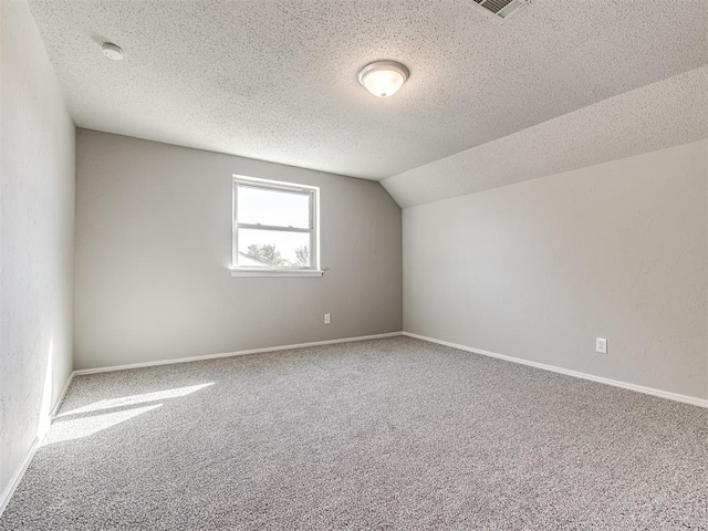 bonus room with carpet flooring, lofted ceiling, and a textured ceiling