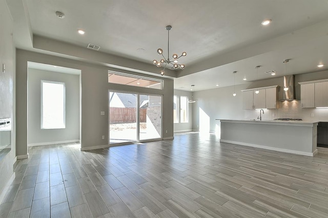 unfurnished living room with a notable chandelier and sink