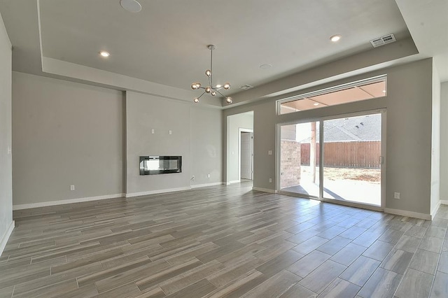 unfurnished living room featuring heating unit and a notable chandelier