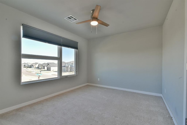 empty room featuring ceiling fan and light colored carpet