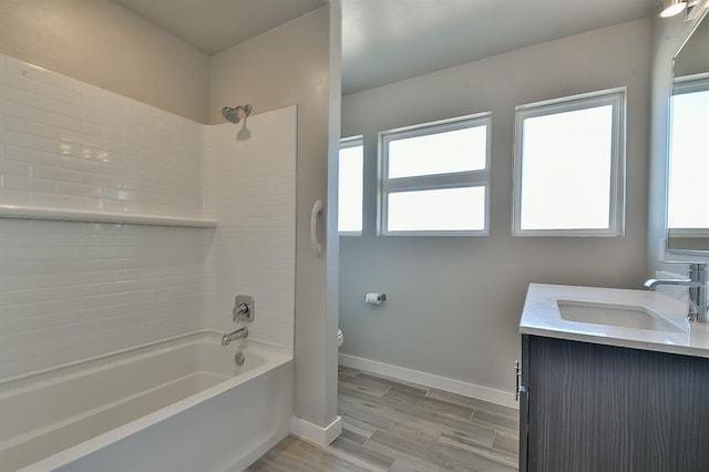 full bathroom featuring bathtub / shower combination, vanity, toilet, and plenty of natural light