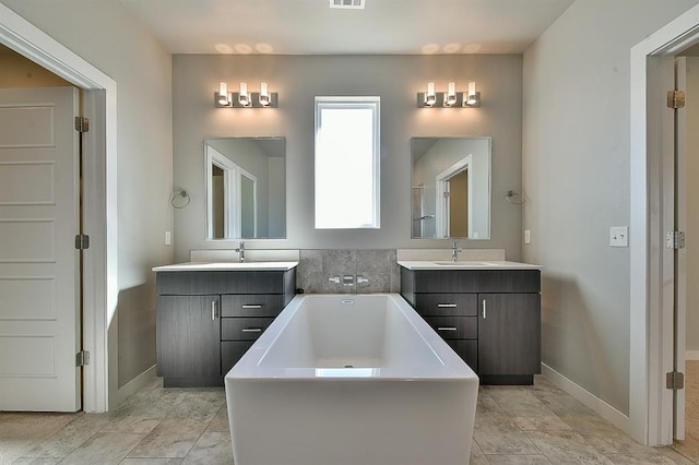 bathroom with a washtub and vanity