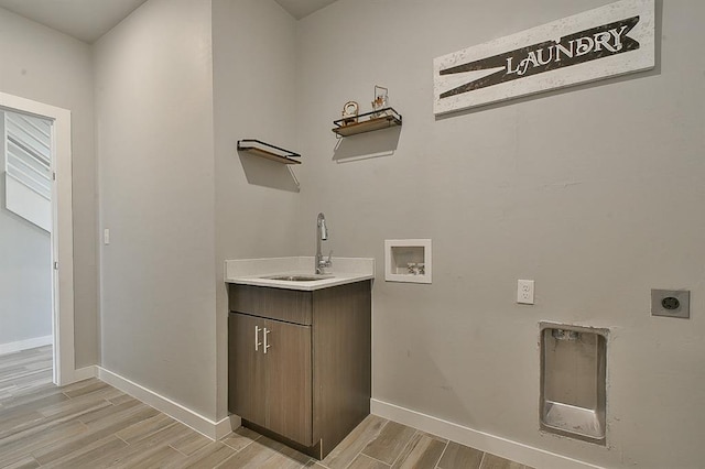 clothes washing area featuring washer hookup, electric dryer hookup, cabinets, and sink