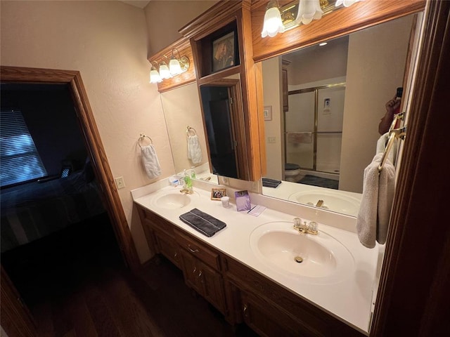 bathroom with vanity, toilet, an enclosed shower, and wood-type flooring