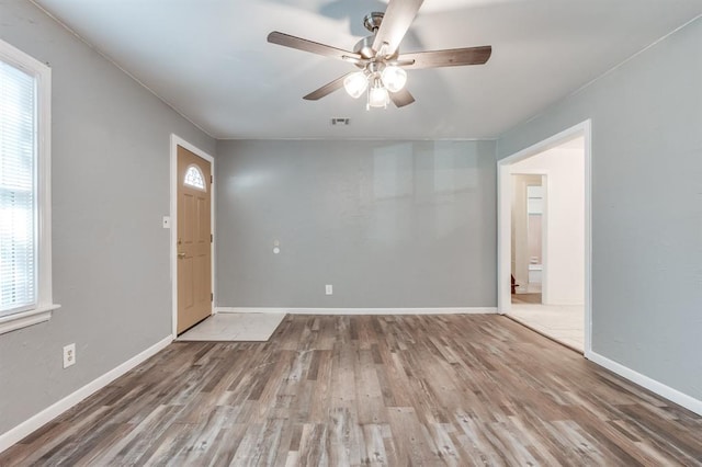 unfurnished room with ceiling fan, plenty of natural light, and wood-type flooring