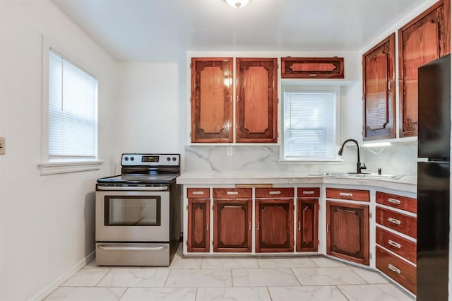 kitchen featuring black refrigerator, tasteful backsplash, stainless steel electric range oven, and sink