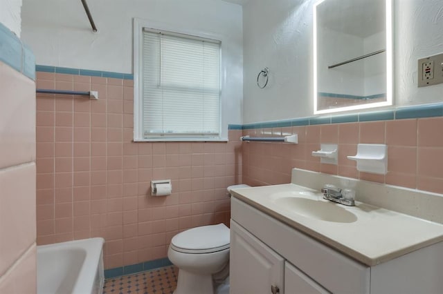 bathroom featuring vanity, a bath, tile walls, and toilet