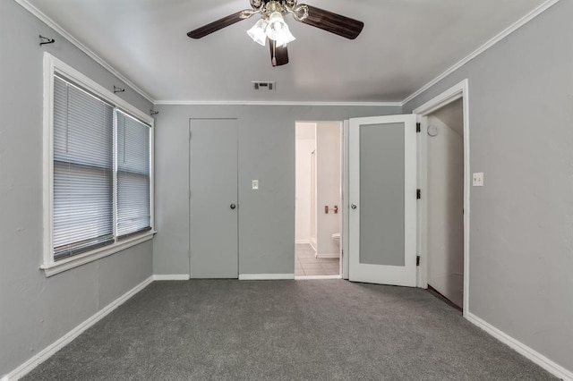 unfurnished bedroom with dark colored carpet, ceiling fan, ornamental molding, and ensuite bath