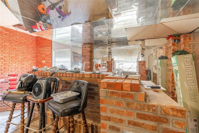 kitchen featuring plenty of natural light and brick wall