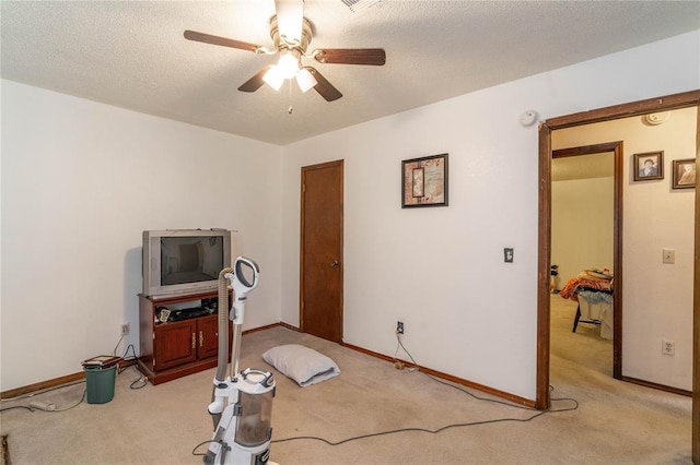 misc room featuring ceiling fan, light colored carpet, and a textured ceiling