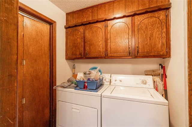 laundry room featuring cabinets, independent washer and dryer, and a textured ceiling