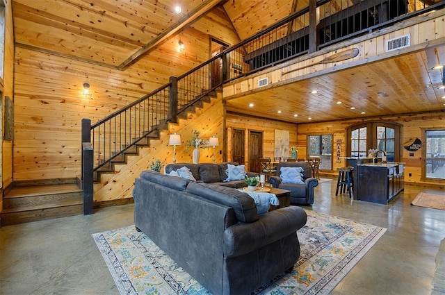 living room with wooden ceiling, wooden walls, and concrete floors