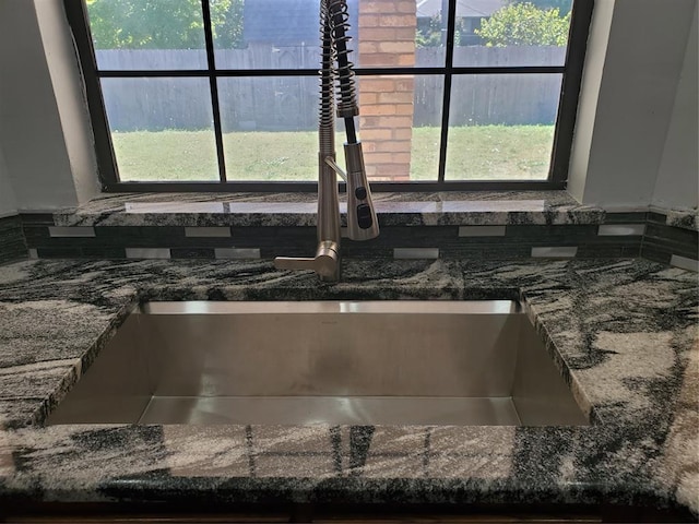 details featuring sink and dark stone counters