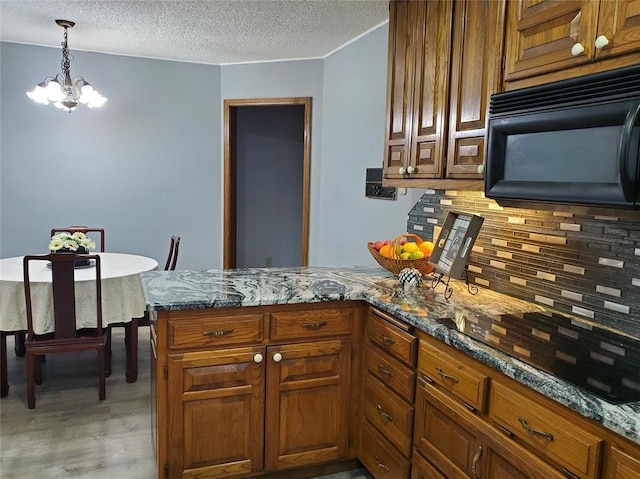 kitchen with kitchen peninsula, stone counters, and a chandelier