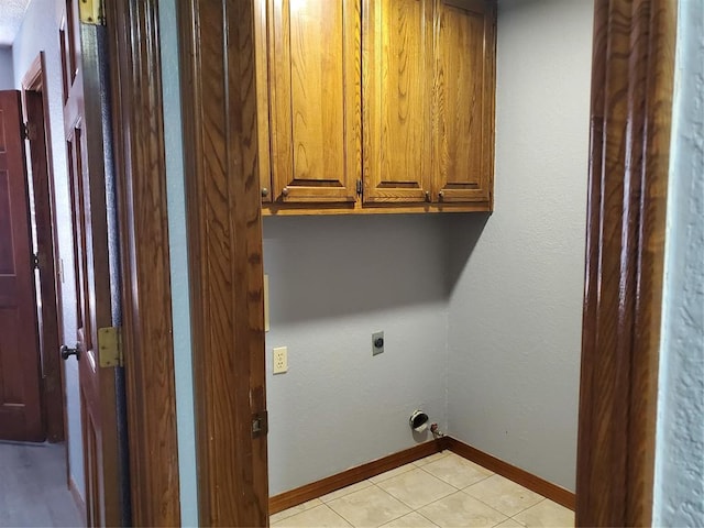 washroom featuring cabinets, light tile patterned floors, and hookup for an electric dryer