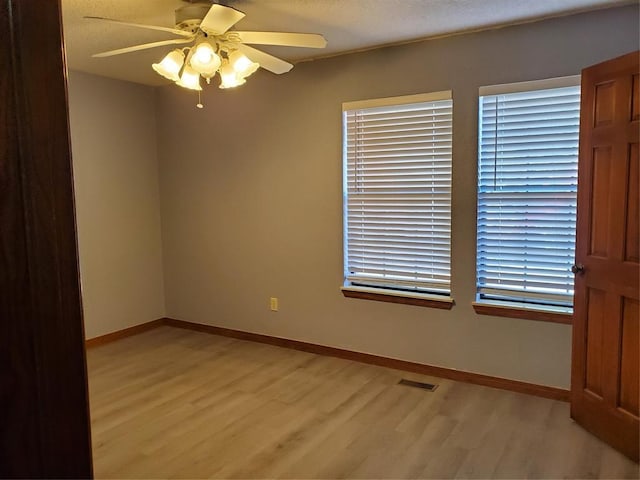 spare room featuring ceiling fan and light hardwood / wood-style flooring