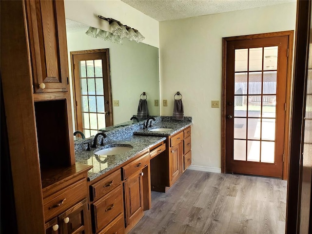 bathroom with hardwood / wood-style flooring, vanity, and a textured ceiling