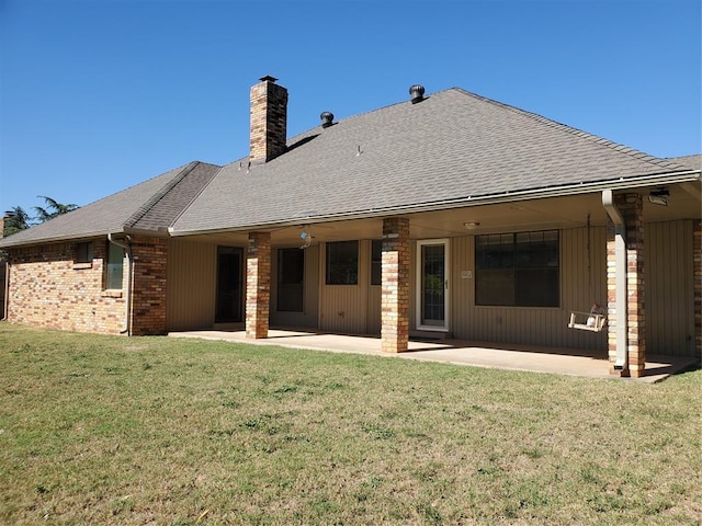 back of property with a patio area and a yard