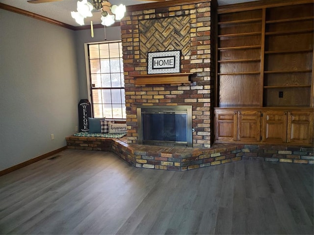 unfurnished living room with hardwood / wood-style floors, ceiling fan, ornamental molding, and a fireplace