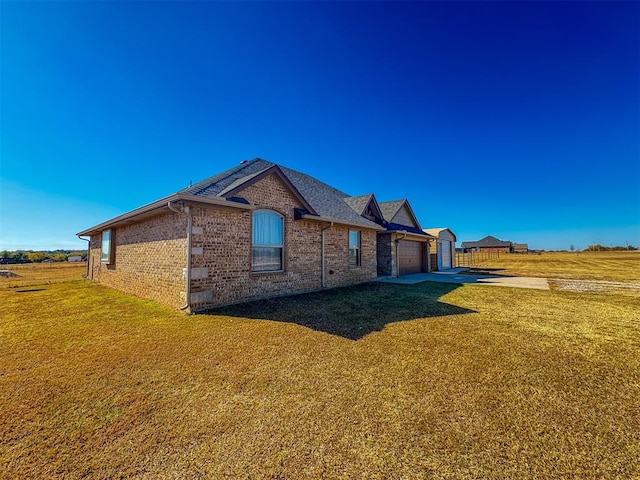 view of side of property with a lawn and a garage