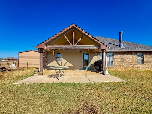 back of property with a yard and a patio