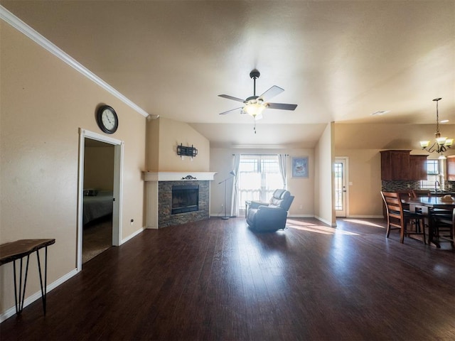 living room with ceiling fan with notable chandelier, sink, ornamental molding, a fireplace, and dark hardwood / wood-style flooring