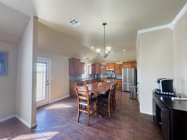 dining space featuring a chandelier, lofted ceiling, dark hardwood / wood-style floors, and crown molding