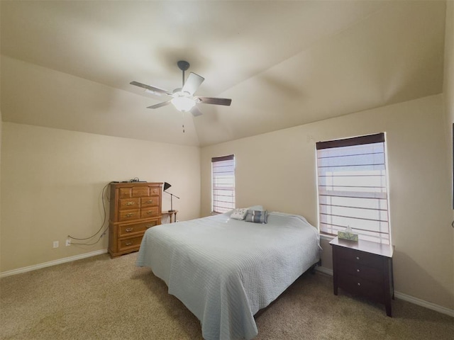 carpeted bedroom featuring ceiling fan, vaulted ceiling, and multiple windows