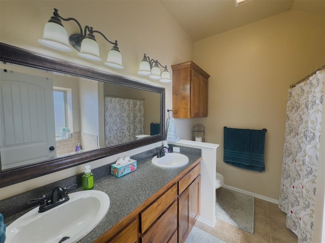 bathroom featuring tile patterned flooring, vanity, toilet, and lofted ceiling