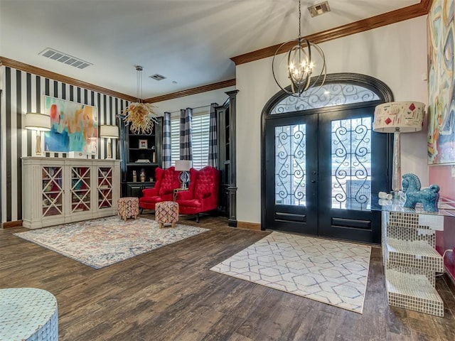 entryway featuring french doors, dark hardwood / wood-style flooring, an inviting chandelier, and ornamental molding