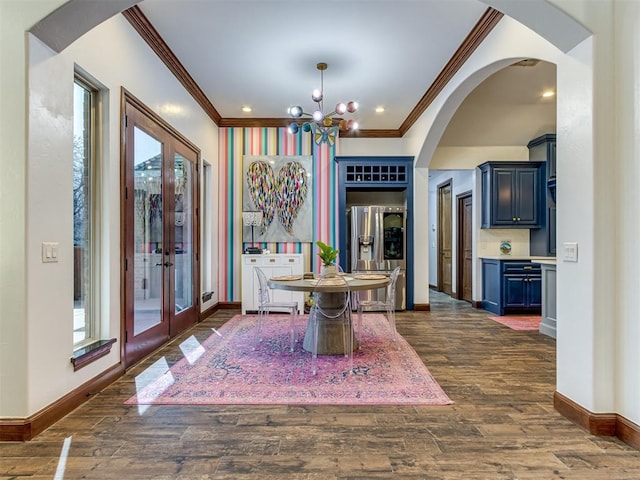 dining space with a notable chandelier, dark hardwood / wood-style floors, crown molding, and french doors