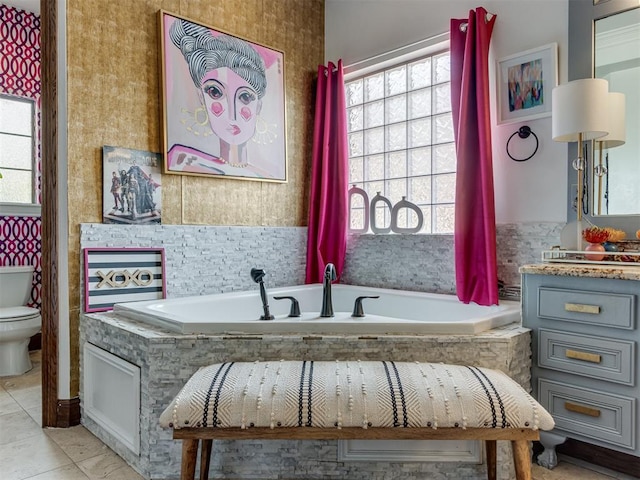 bathroom with tile patterned flooring, toilet, and tiled tub