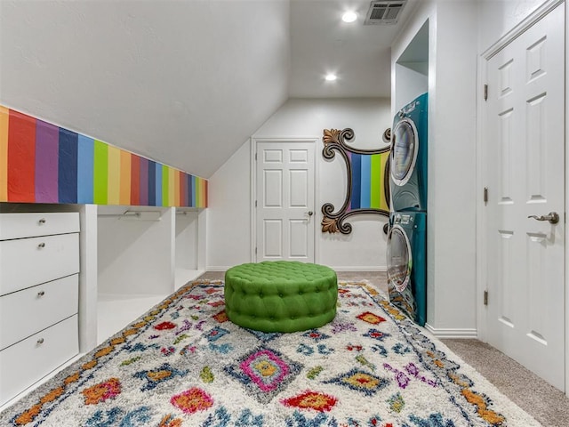 interior space with light colored carpet, lofted ceiling, and stacked washer / dryer