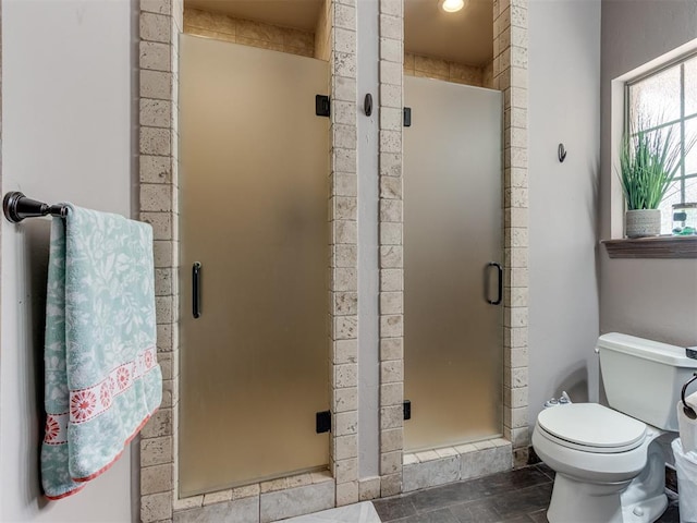 bathroom featuring tile patterned floors, an enclosed shower, and toilet