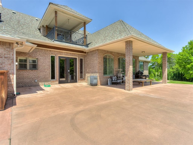 back of property with a patio area, french doors, and a balcony