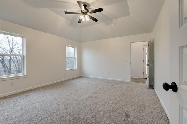 empty room with light carpet, baseboards, vaulted ceiling, and a ceiling fan