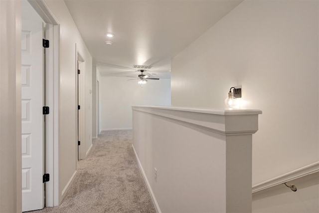 hall featuring baseboards and light colored carpet