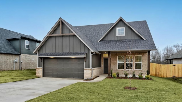 view of front facade with driveway, fence, a front yard, an attached garage, and brick siding