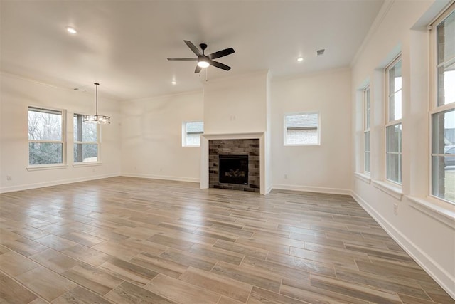 2348 Ridge Pine Rd, Edmond, OK 73034 - unfurnished living room featuring a fireplace, crown molding, a chandelier, ceiling fan, and light wood finished floors