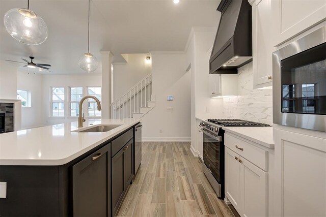 2348 Ridge Pine Rd, Edmond, OK 73034 - kitchen featuring gas range oven, custom exhaust hood, a ceiling fan, light countertops, and tasteful backsplash